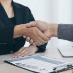 Impiegata stringe il mano al datore di lavoro