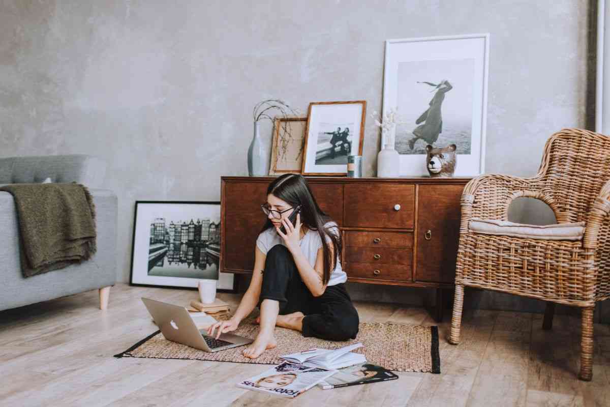 Ragazza che parla al telefono mentre utilizza un portatile